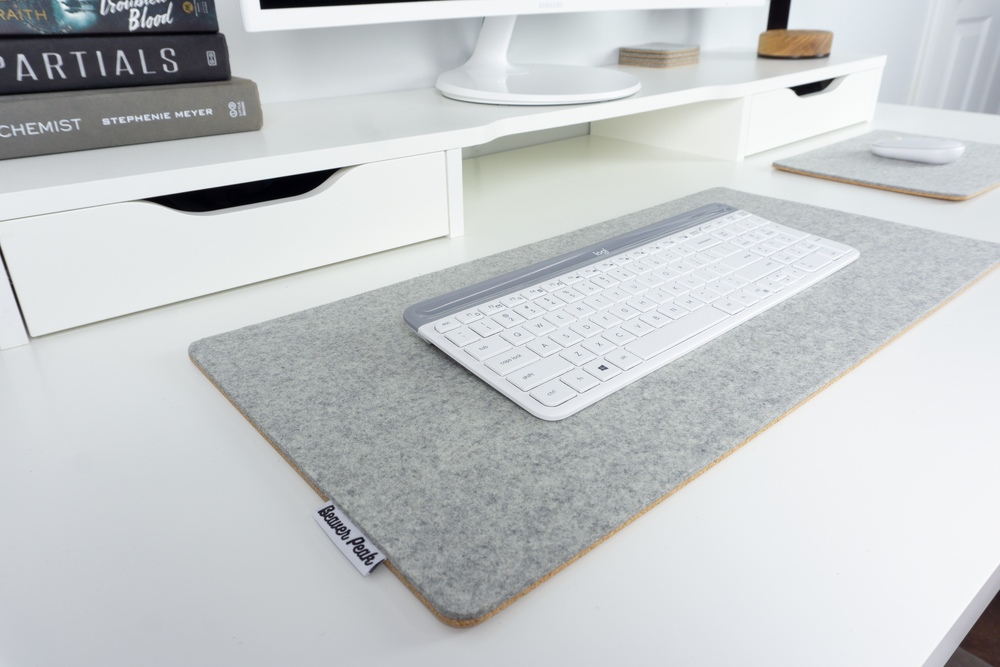 Grey wool felt and cork desk mat with white keyboard on top