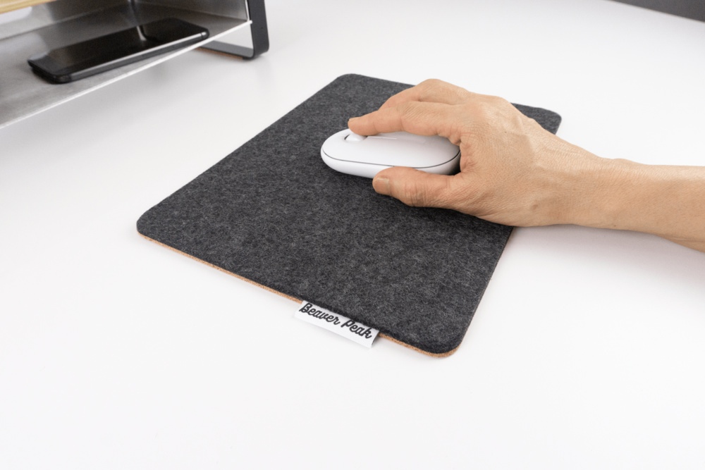 Black wool felt mouse pad with hand using white mouse.