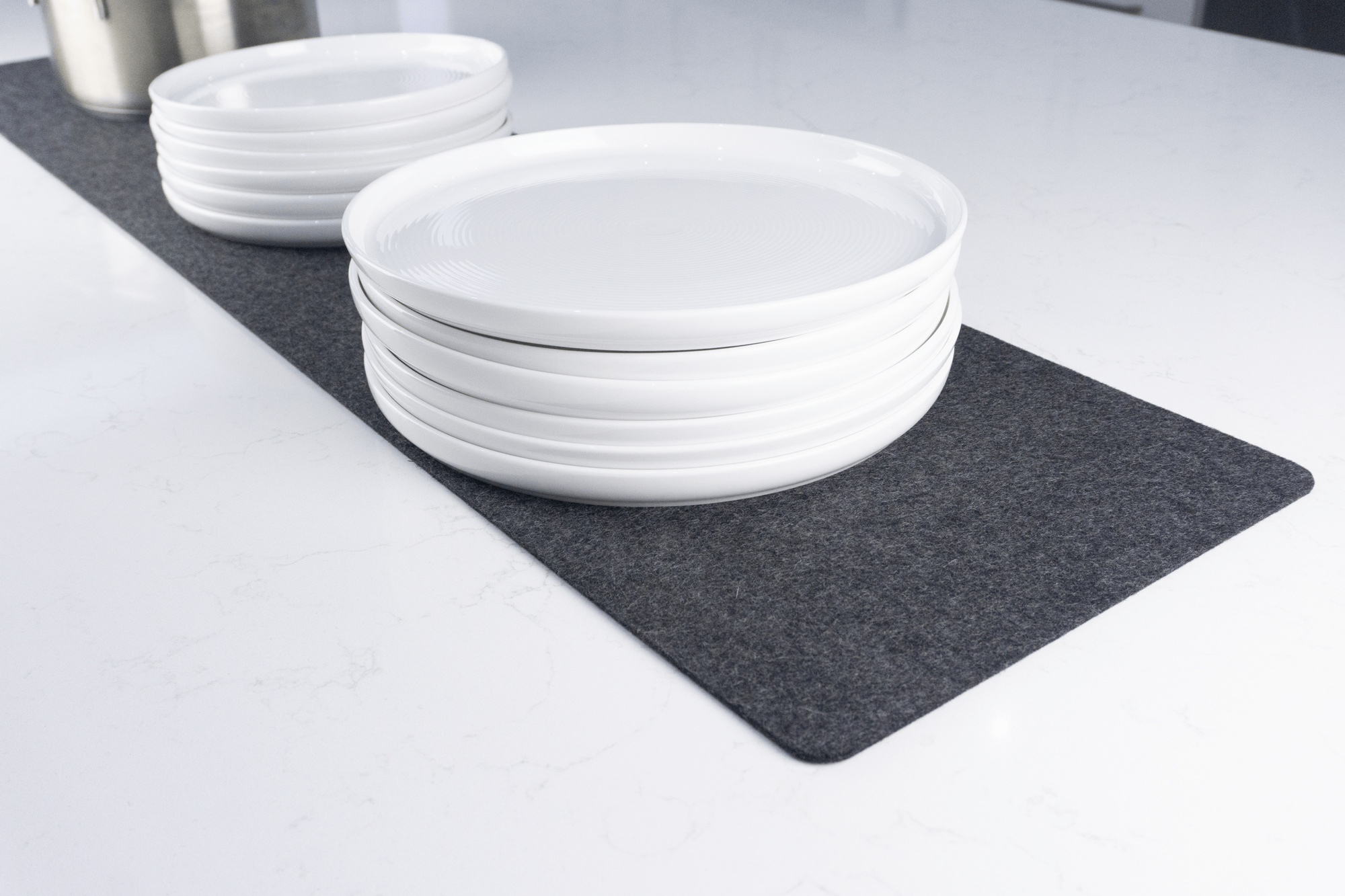 Black wool table runner with stacks of plates on top