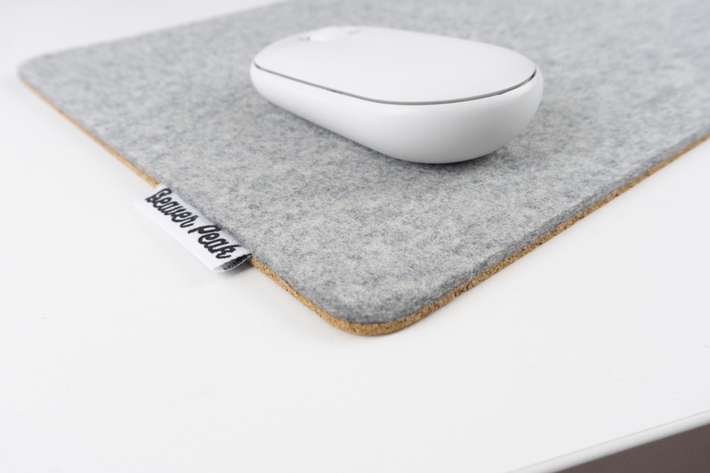 Close up of grey wool felt mouse pad with white mouse