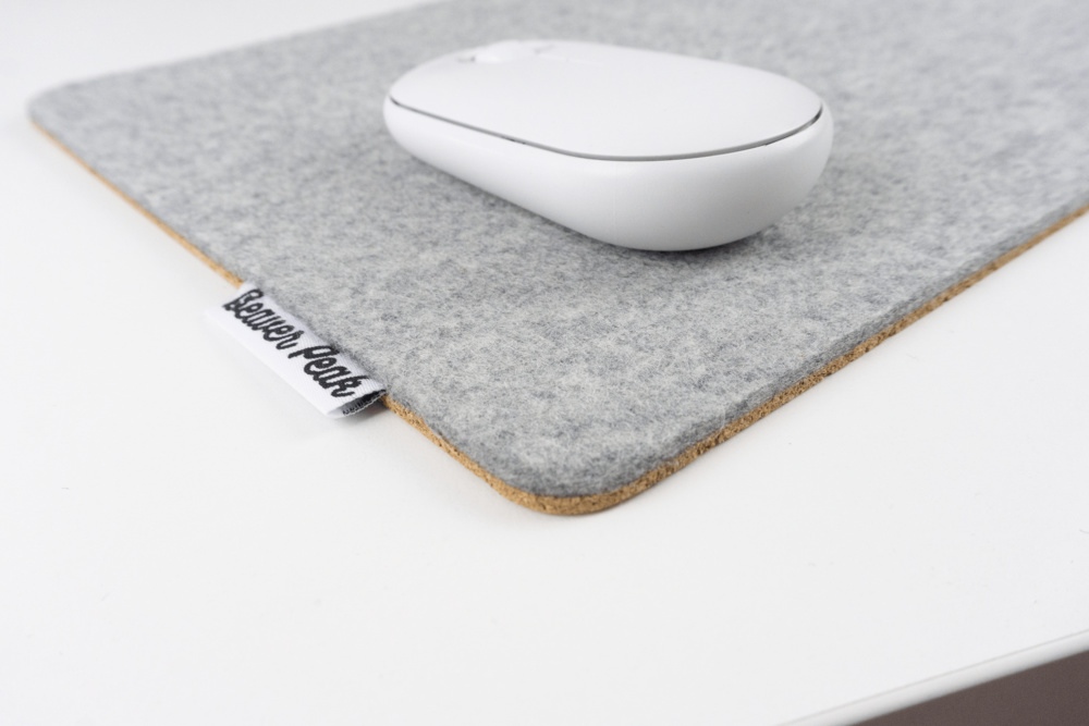 Close up of grey wool felt mouse pad with white mouse.