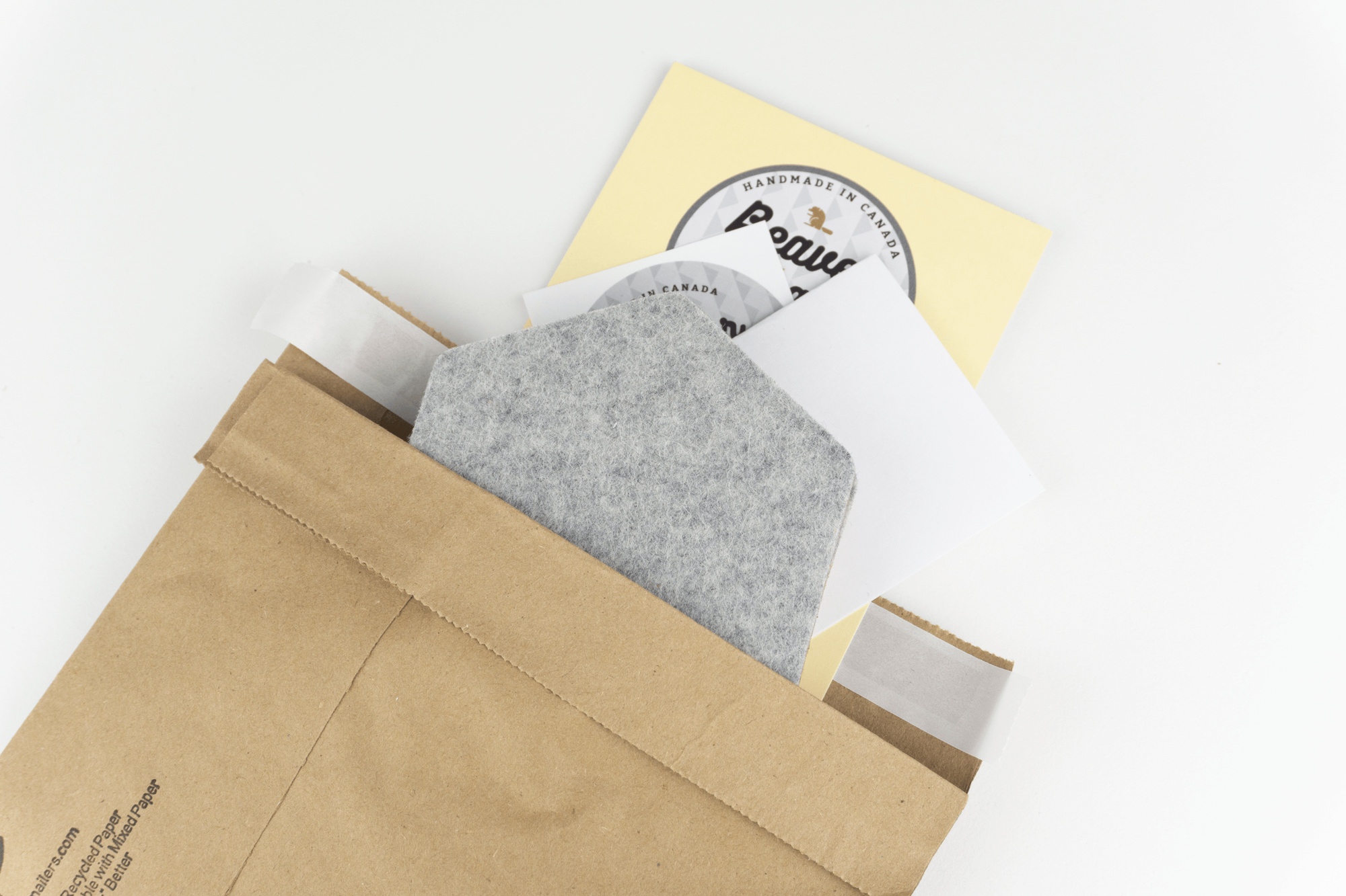 The recyclable kraft paper packaging we use for our hexagon desk coasters shown up close against a white background.