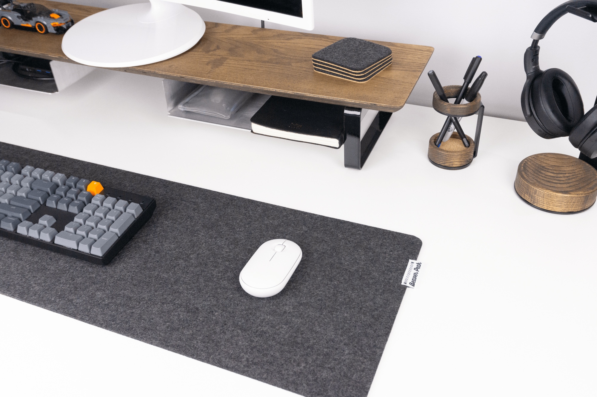 Black wool desk mat with walnut desk shelf, pen stand, and headphone stand.