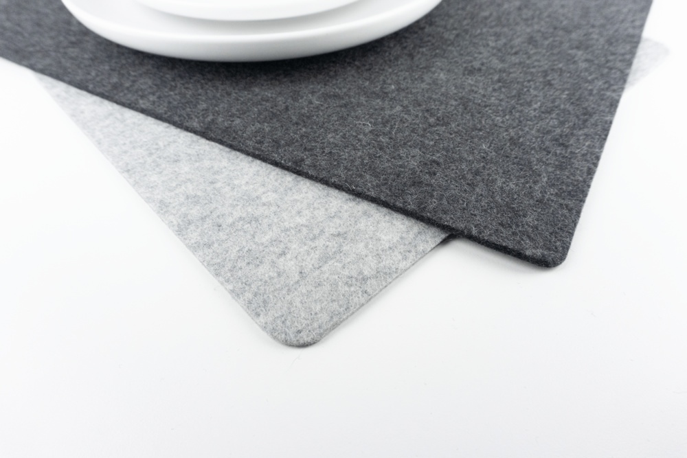 Colour comparison between black and grey wool felt placemats.