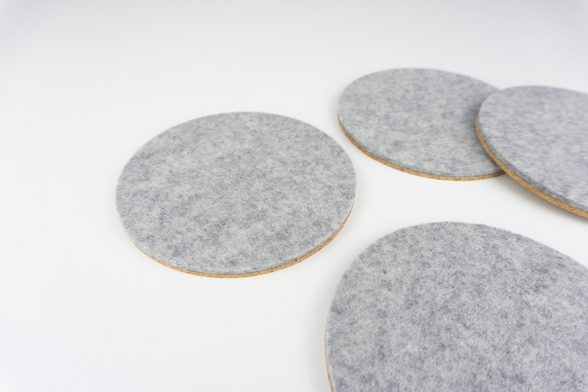 A set of our grey circle coasters shown spread out on a white coffee table.