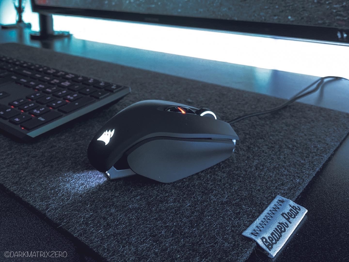 Gaming mouse on a black merino wool felt desk mat.