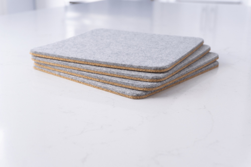 Set of 4 wool felt trivets in grey merino wool, shown stacked.