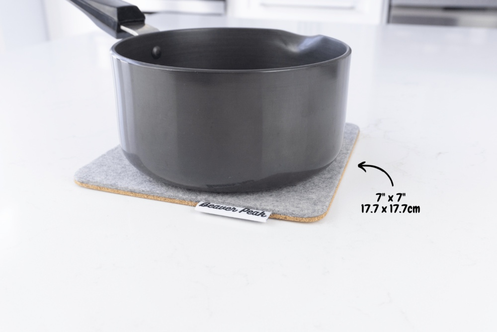 Grey merino wool felt trivet with black metal pot on top with dimensions showing: 7 x 7 inches, 17.7 x 17.7 inches