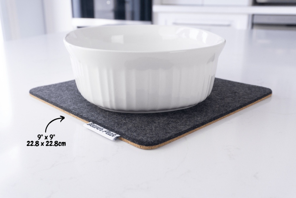 Black wool felt trivet with white ceramic pot on top, showing dimensions: 9 x 9 inches, 22.8 x 22.8 cm
