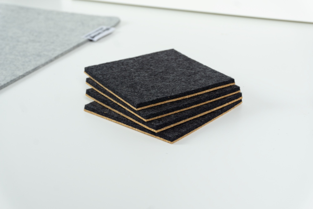 Merino wool coaster set of 4 in black felt with square corners.